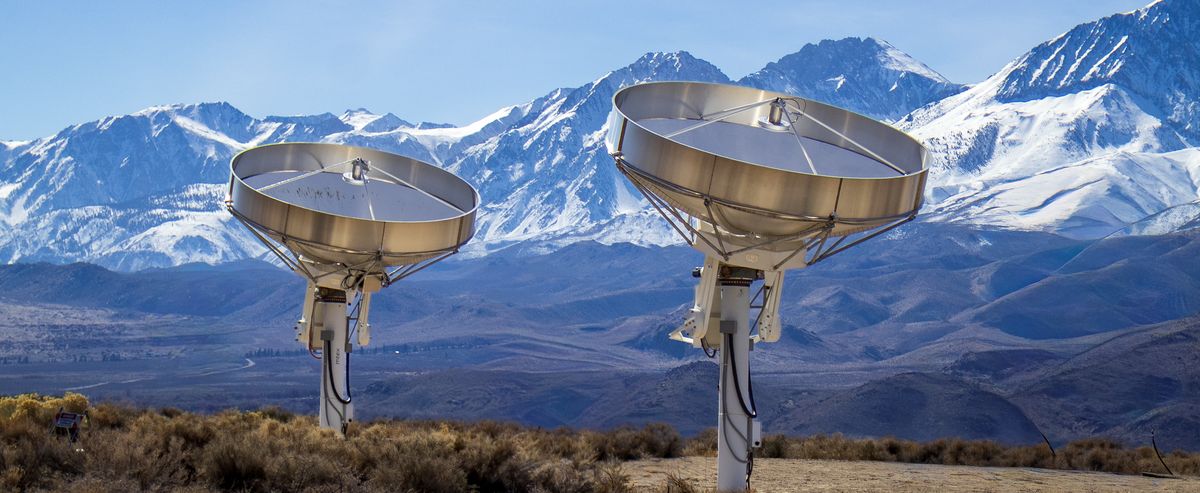Two DSA prototype antennas in Owens Valley with the snow-covered Sierra Nevada behind them